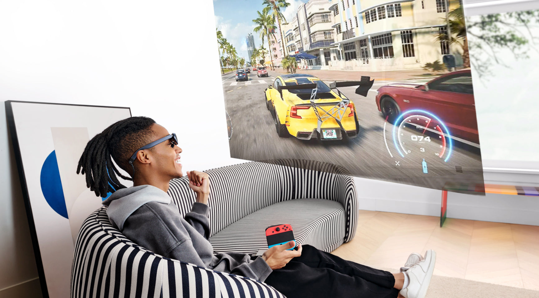 A man sitting on the sofa using Rokid Max AR smart glasses for gaming