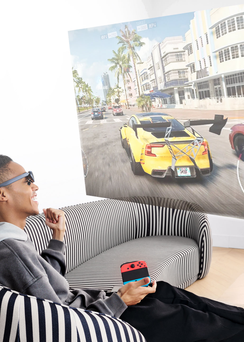 A man sitting on the sofa using Rokid Max AR smart glasses for gaming